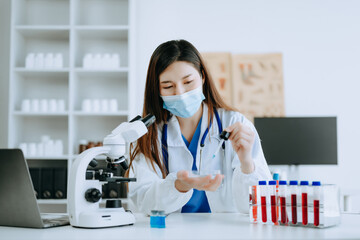 Young scientists conducting research investigations in a medical laboratory, a researcher in foreground is using a microscope in laboratory for medicine.  .