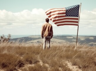 person in front of american flag on top of the mountain