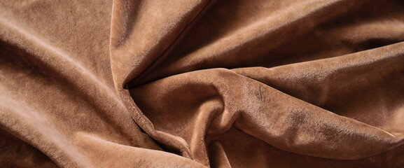 Brown soft velvet fabric with drapery. velvet draped velour background. Wrinkled cloth fabric banner