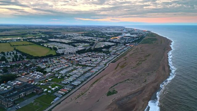 Drone video reveals Skegness coastal beauty at sunset: holiday park, beach, caravans, and sea.