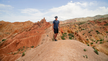 Fototapeta premium Rear view of man standing at the cliff edge enjoying view from National Canyon. Adventure seeker embraces nature beauty. Tranquil and majestic atmosphere in wilderness