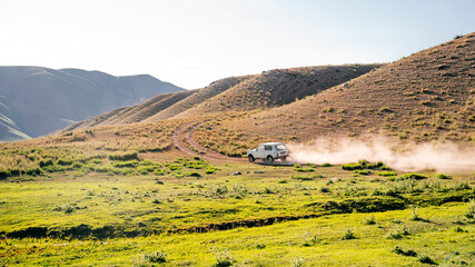 Naklejka premium Different jeeps on off-road trip in the green Tien Shan Mountains in Kensu river area in the summer. Rich unique nature of Central Asia