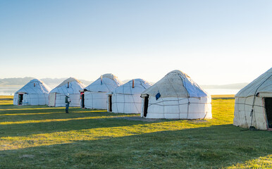 Yurt camp at Song Kul Lake during sunset. Travel to Kyrgyzstan to discover the nomadic life of the nomads camping and in yurt camps.