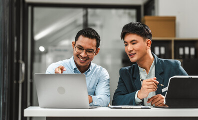 Serious young business asian man supervisor analyse financial report of responsible worker pay...