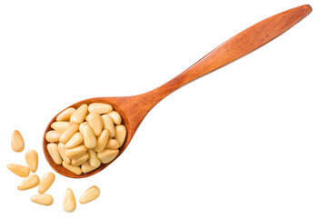 Roasted pine nuts in the wooden spoon, isolated on the white background, top view.