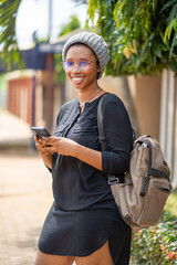 portrait of beautiful african lady with smart phone outside