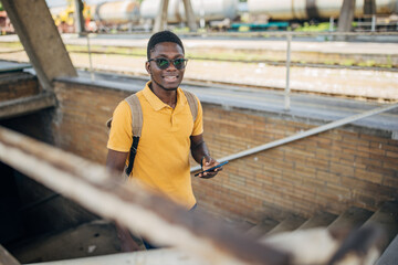 Fototapeta premium Young man with headphones and mobile phone on the train station