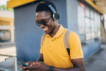 Young man with headphones and mobile phone on the train station