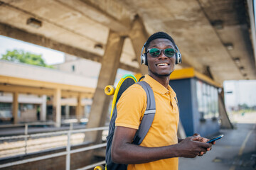Young man with skateboard waiting for train