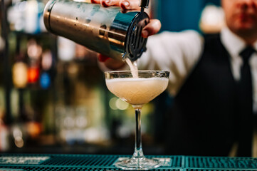 man hand bartender making cocktail in glass on the bar counter