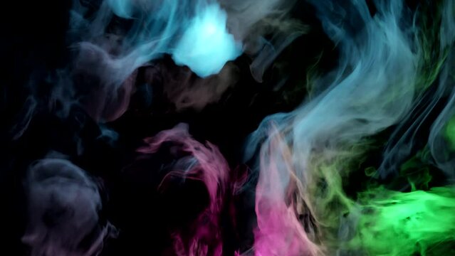 Color paint drops in water or smoke in slow motion. Abstract color mix — pink, blue, green. Colorful smokes background.