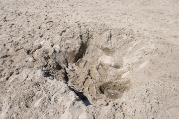 hole in the sand on the beach made by children at playing