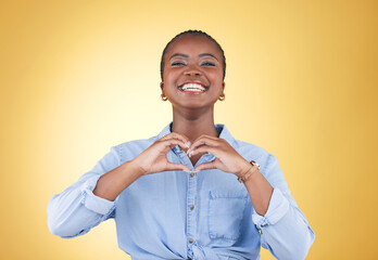 Portrait, heart hands and black woman, smile and studio isolated on yellow background. Face, love...