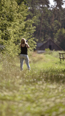 girl photographer photographing nature, walking in the woods, back view. young woman in spring forest. girl tourist. enjoying spring weather. Rest, lifestyle, walk in the fresh air. hiking in nature