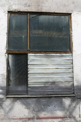 Broken glass window on a concrete wall in an industrial zone