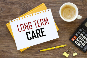 Long Term Care Insurance. words on a white page. hard notepad. working environment