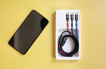 Folded USB lightning cable isolated over the yellow  background. Three types of peripheral...