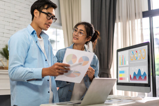 Couple relax using laptop work, analyzing data management system make report with KPI, analytics, strategy, finance, sales, marketing, money, business growth, financial investment graph at home