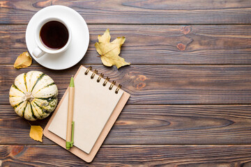 Autumn composition: fallen leaves and craft sketchbook mock up on colored background. Top view. Flat lay with copy space