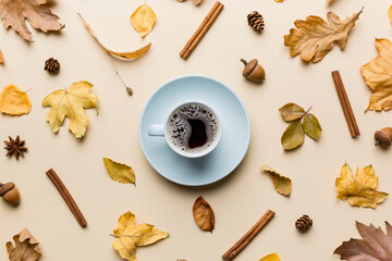 Flat lay composition with colorful Autumn cup of coffee and leaves on a color background. top view