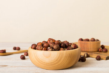 Wooden bowl full of hazelnuts on table background. Healthy eating concept. Super foods