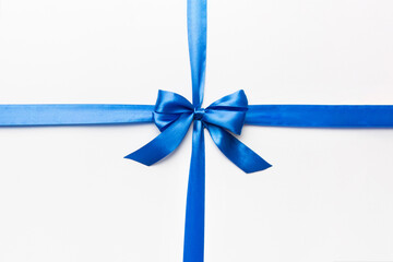 Top view of blue ribbon rolled and blue bow isolated on colored background. Flat lay with copy space