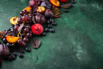 Assortment of purple fruit plum, grape, blueberry and basil