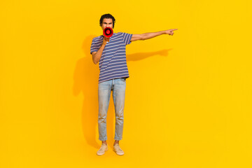 Fototapeta premium Full size photo of negative furious man hold scream loudspeaker direct finger empty space isolated on yellow color background