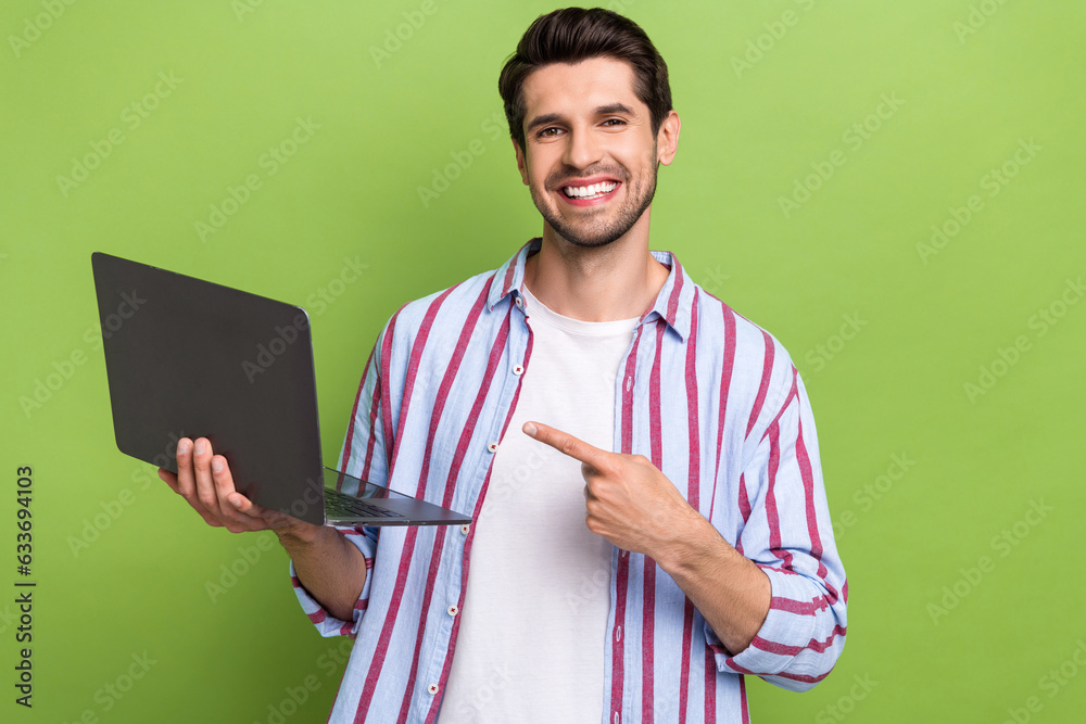 Poster portrait of young positive man indicate finger empty space laptop high efficiency new technologies i