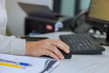 Businessman sits at his desk, engrossed in his work on computer.