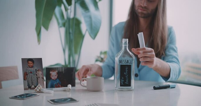 Young man trying to introduce a letter in a bottle. 