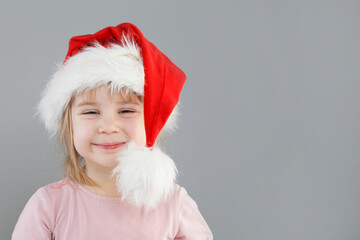 Happy cute baby small girl in Santa hat, Christmas portrait