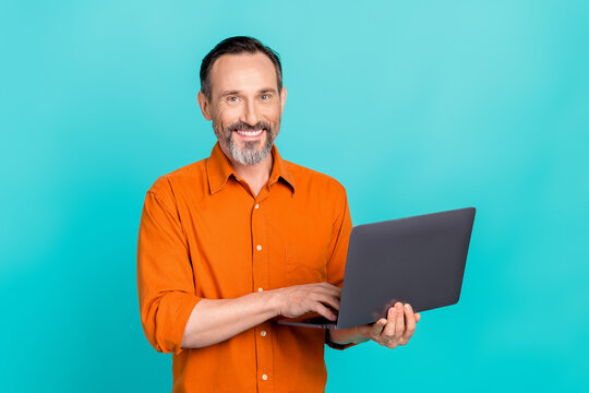 Photo of cheerful clever nice man with white gray beard wear stylish shirt typing email on lapotop isolated on teal color background
