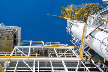 Close up view of industry at oil refinery plant as industrial field with sunlight and sky.