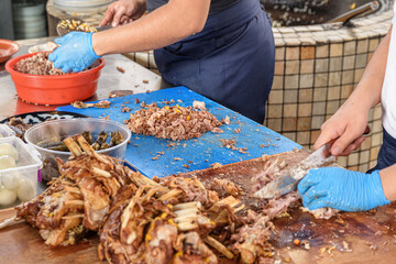 Cookers are cutting meat from plov (pilaf) for serving, Tashkent