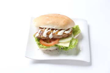 speciality grilled bbq chicken chop burger bun with cheese, vegetables and salad sauce breakfast in plate on white background western chef appetiser halal bakery food restaurant pastry menu for cafe