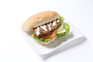 speciality grilled bbq chicken chop burger bun with cheese, vegetables and salad sauce breakfast in plate on white background western chef appetiser halal bakery food restaurant pastry menu for cafe