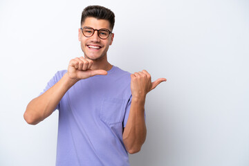 Young caucasian man isolated on white background pointing to the side to present a product