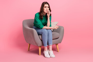 Fototapeta na wymiar Full length photo of nervous unhappy lady wear green shirt sitting chair looking empty space isolated pink color background