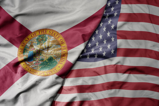 big waving colorful national flag of united states of america and flag of florida state .