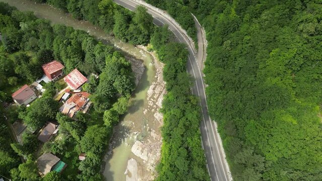 Water streaming in the Putna river next to an empty road in Lepsa. Drone dolley shot