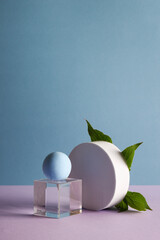 dimensional compositions of geometric shapes concept. transparent cube with circles and leaves on blue background. copy space. abstract and still life