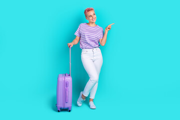 Full body length cadre of young lady wear striped t shirt point finger empty space travel around ukraine isolated on blue color background