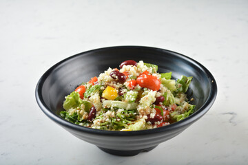 couscous healthy grain salad bowl with corn, bean, carrot and salad dressing sauce on white marble table background chef cook healthy poke bowl halal vegan food menu