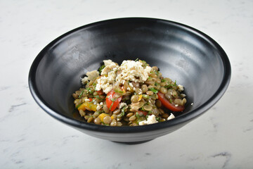 trio quinoa grain salad bowl with avocado, tomato, pea bean, carrot and brown rice in black bowl on white marble table background chef cook healthy poke bowl halal vegan food menu