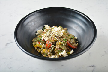 trio quinoa grain salad bowl with avocado, tomato, pea bean, carrot and brown rice in black bowl on white marble table background chef cook healthy poke bowl halal vegan food menu