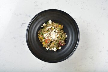 trio quinoa grain salad bowl with avocado, tomato, pea bean, carrot and brown rice in black bowl on white marble table background chef cook healthy poke bowl halal vegan food menu