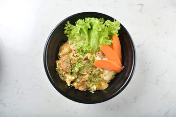 japanese oyakodon chicken fried egg white rice with carrot vegetable salad in black bowl on wood tray white marble table background chef cook healthy poke bowl halal vegan food menu