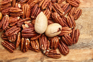 Pecan nuts texture background closeup. Heap of pecan halves. Peeled pecan nuts on wooden background, top view