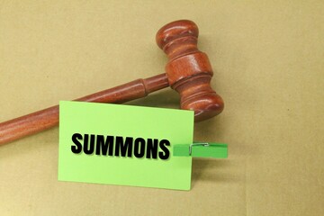 judge's gavel and colored paper with the word SUMMONS. an order to appear before a judge or magistrate